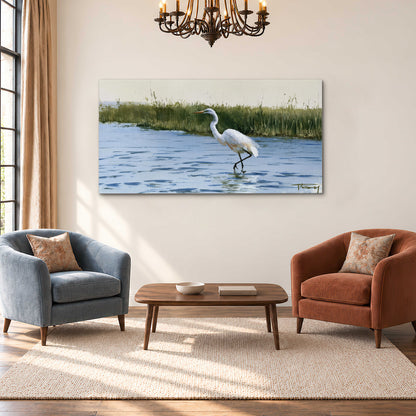 A white heron wading through bright blue water beside green reeds single canvas wall art styled in an interior