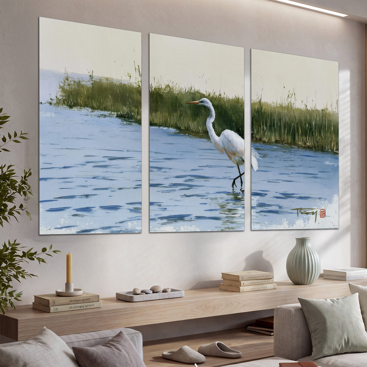 A white heron wading through bright blue water beside green reeds set of 3 poster prints displayed in a console