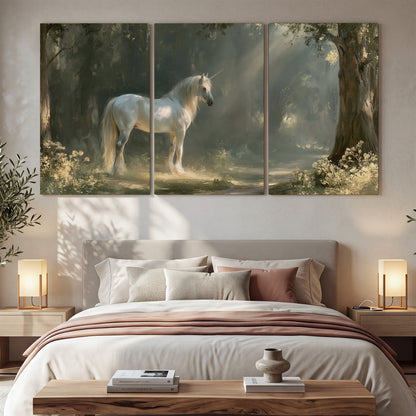 A white unicorn standing beneath arching trees in a softly lit woodland 3 piece canvas wall art displayed in a bedroom