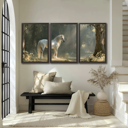 A white unicorn standing beneath arching trees in a softly lit woodland 3 piece framed canvas wall art displayed in a entryway
