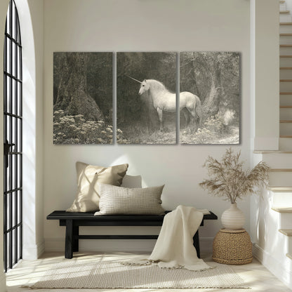 A pale unicorn surrounded by fine gray woodland branches and soft mist 3 piece canvas wall art displayed in a entryway