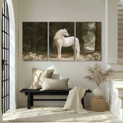 A white unicorn standing in a shadowed forest clearing among dark tree trunks 3 piece canvas wall art displayed in a entryway