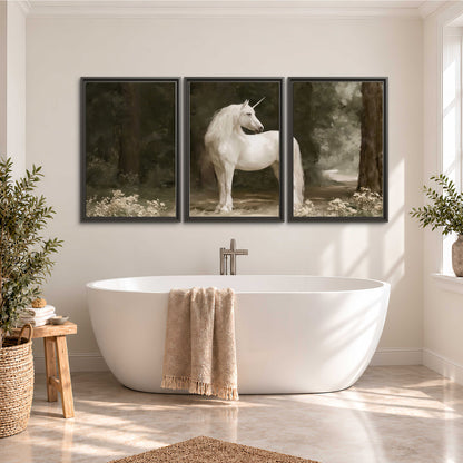A white unicorn standing in a shadowed forest clearing among dark tree trunks 3 piece framed canvas wall art styled in an interior