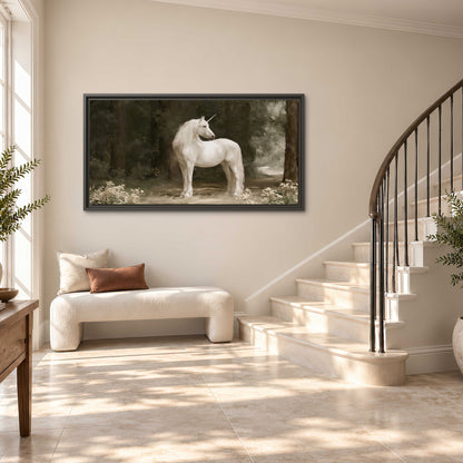 A white unicorn standing in a shadowed forest clearing among dark tree trunks single framed canvas wall art styled in an interior