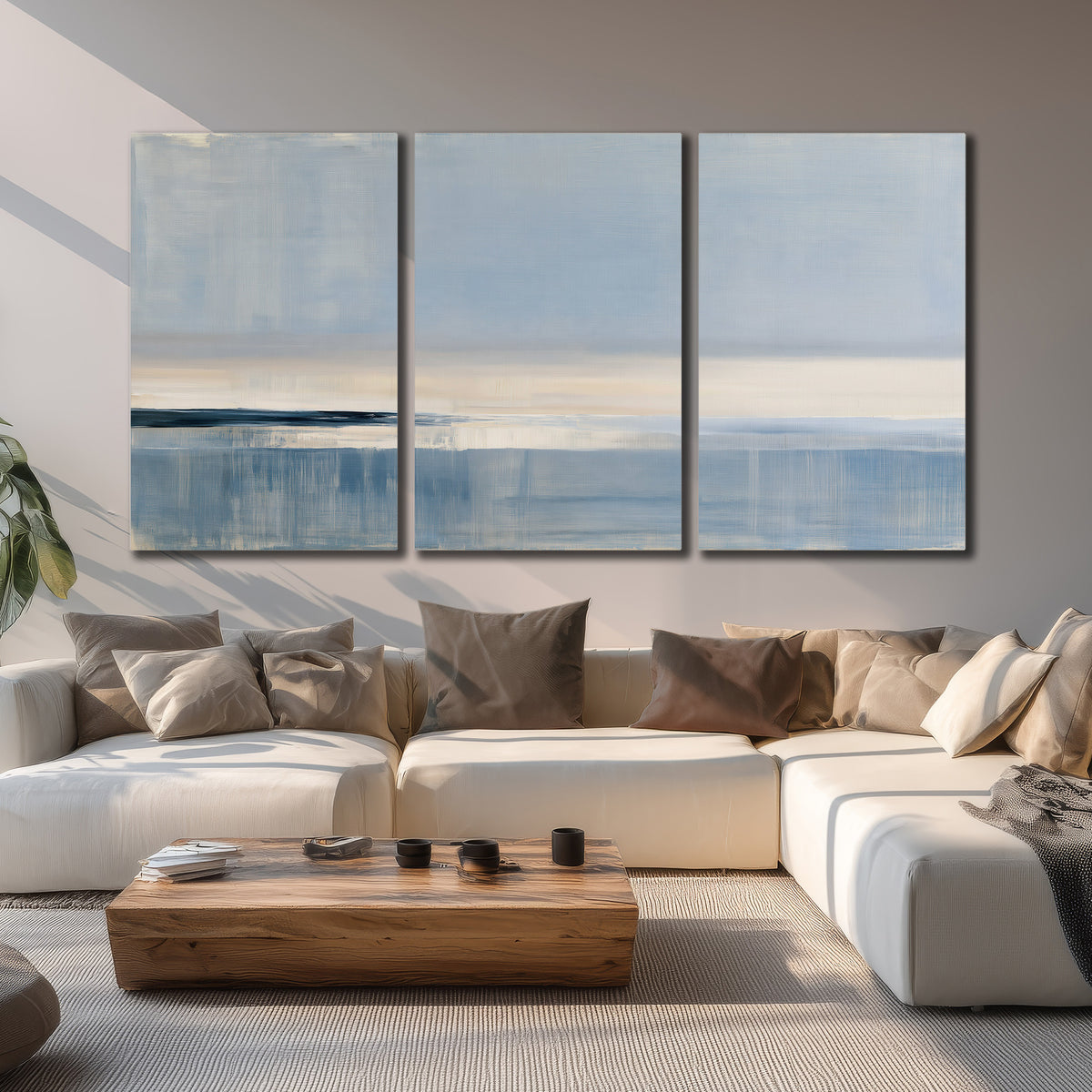 A minimal blue seascape with a pale horizon and soft vertical reflections 3 piece canvas wall art displayed in a living room