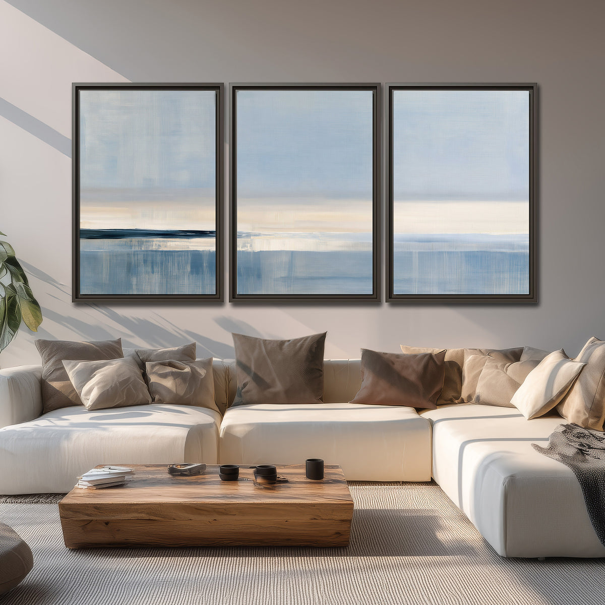 A minimal blue seascape with a pale horizon and soft vertical reflections 3 piece framed canvas wall art displayed in a living room