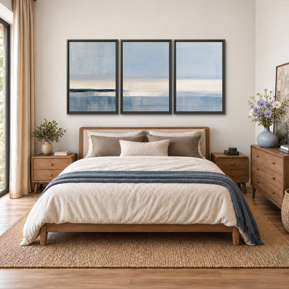 A minimal blue seascape with a pale horizon and soft vertical reflections 3 piece framed canvas wall art styled in an interior