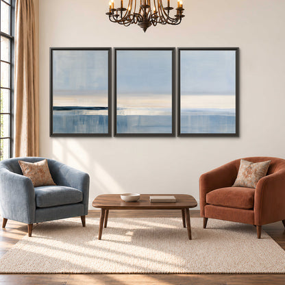 A minimal blue seascape with a pale horizon and soft vertical reflections 3 piece framed canvas wall art styled in an interior