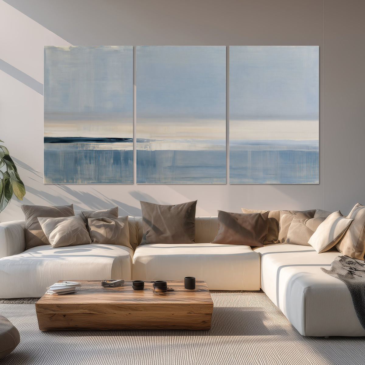 A minimal blue seascape with a pale horizon and soft vertical reflections set of 3 poster prints displayed in a living room