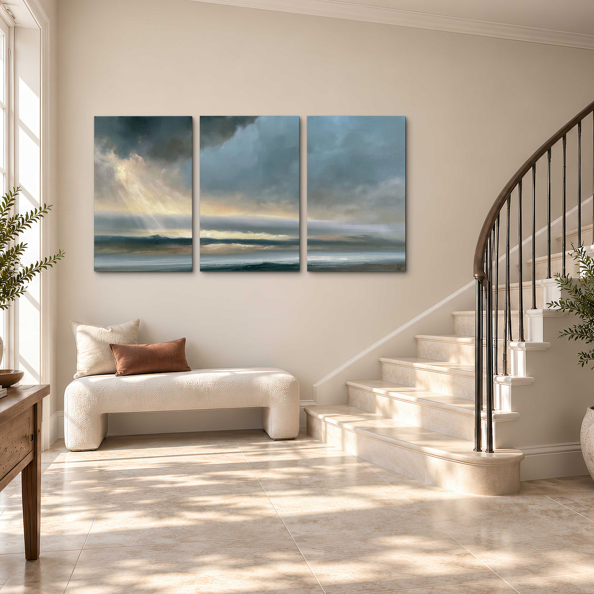 Dramatic blue-gray storm clouds breaking over a pale strip of ocean light 3 piece canvas wall art styled in an interior