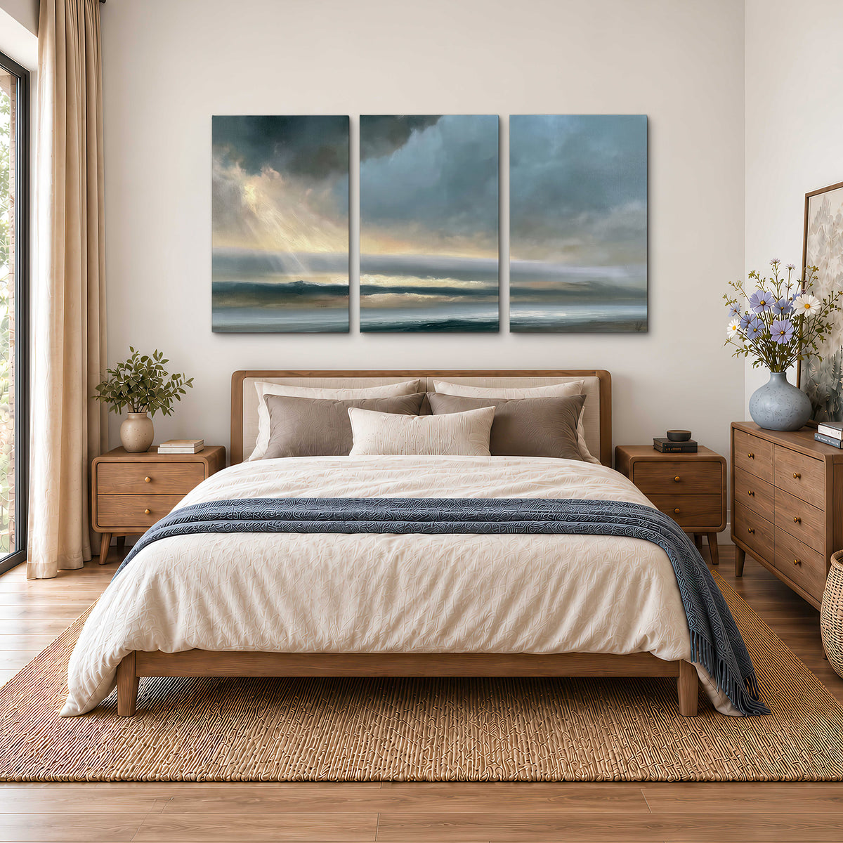 Dramatic blue-gray storm clouds breaking over a pale strip of ocean light 3 piece canvas wall art styled in an interior