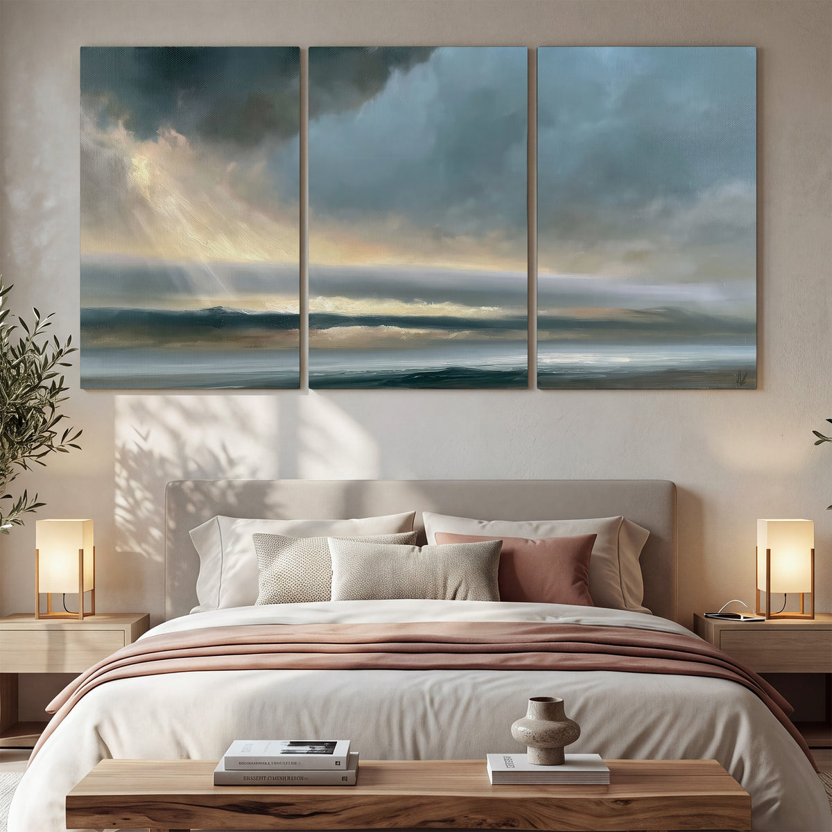 Dramatic blue-gray storm clouds breaking over a pale strip of ocean light 3 piece canvas wall art displayed in a bedroom
