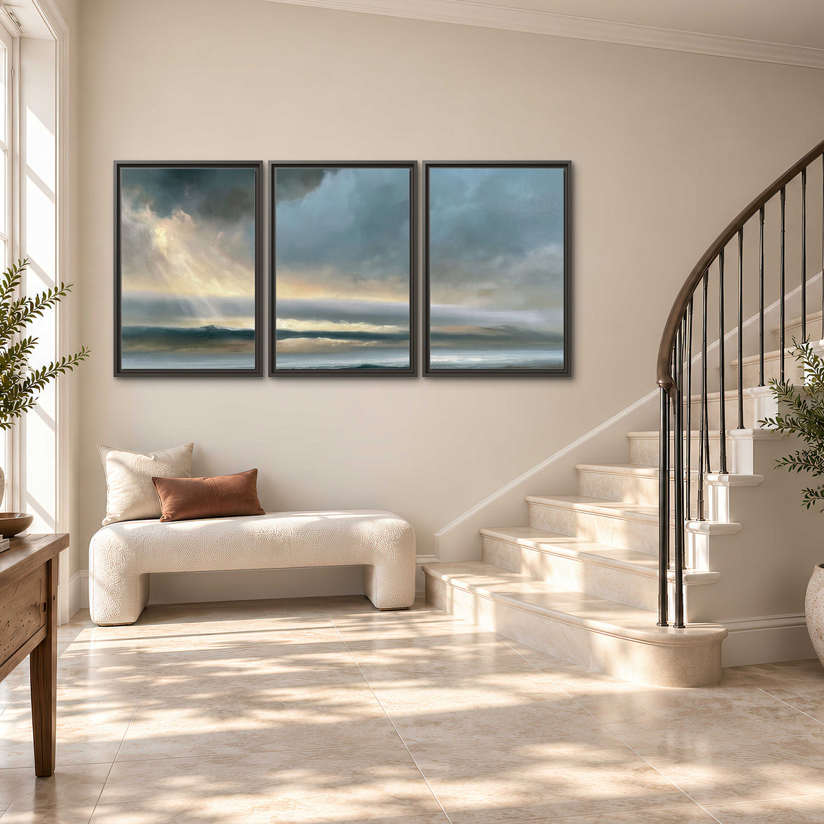 Dramatic blue-gray storm clouds breaking over a pale strip of ocean light 3 piece framed canvas wall art styled in an interior