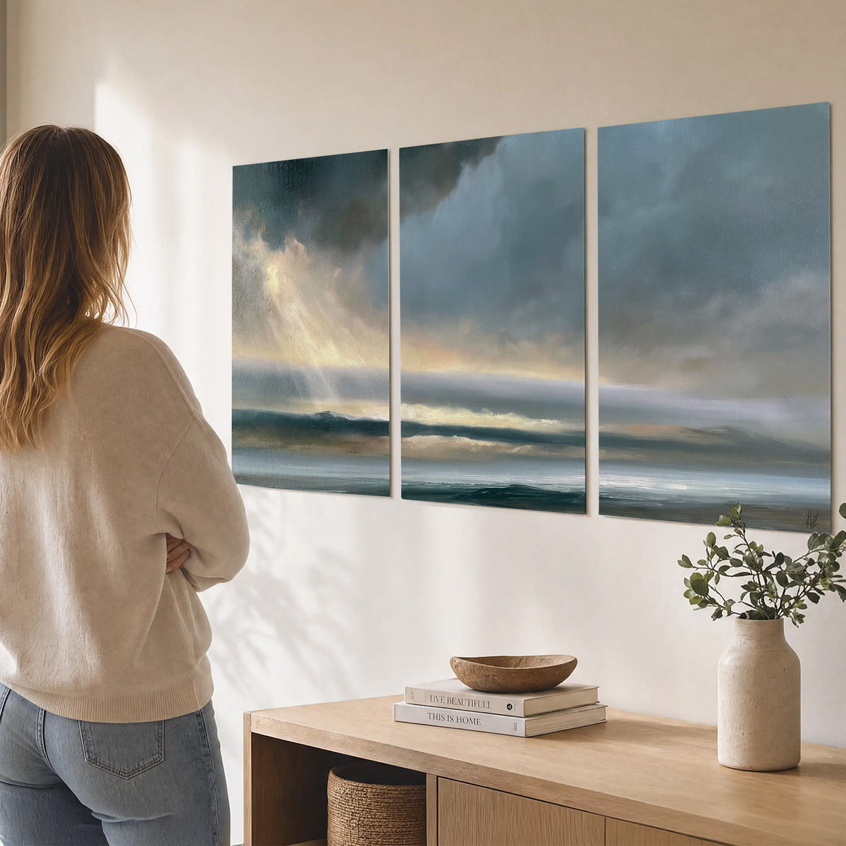 Dramatic blue-gray storm clouds breaking over a pale strip of ocean light set of 3 poster prints three panel arrangement on a wall