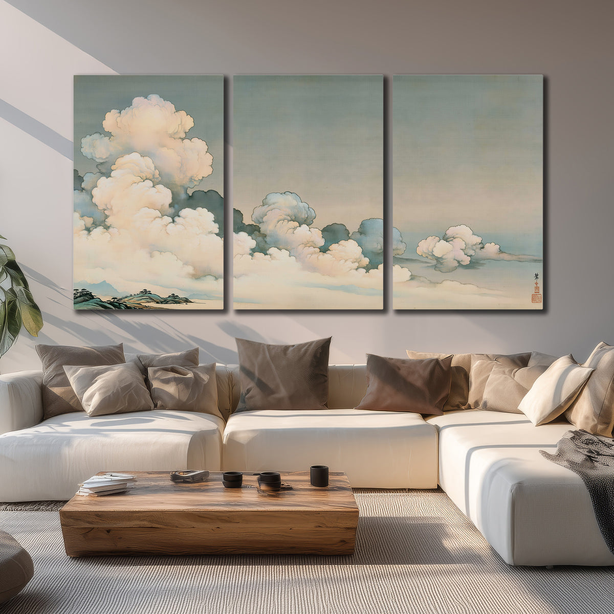 Soft cream clouds gathered low in a muted blue-green sky 3 piece canvas wall art displayed in a living room