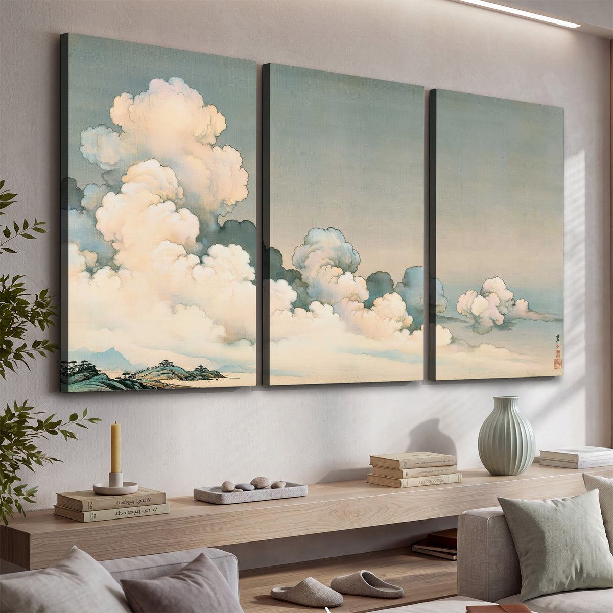 Soft cream clouds gathered low in a muted blue-green sky 3 piece canvas wall art displayed in a console