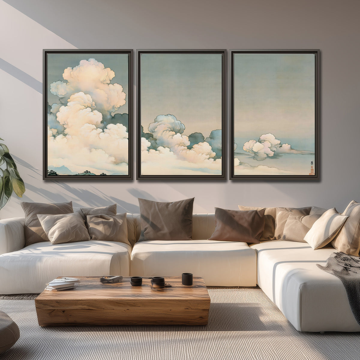 Soft cream clouds gathered low in a muted blue-green sky 3 piece framed canvas wall art displayed in a living room