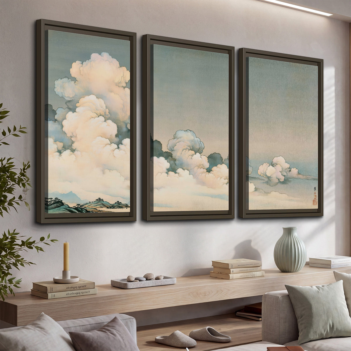 Soft cream clouds gathered low in a muted blue-green sky 3 piece framed canvas wall art displayed in a console