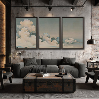 Soft cream clouds gathered low in a muted blue-green sky 3 piece framed canvas wall art displayed in a industrial room