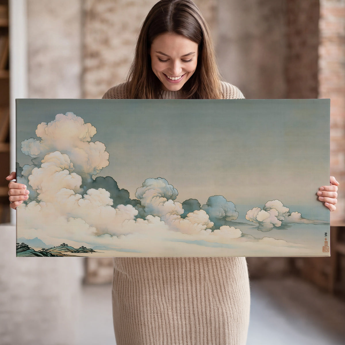 Soft cream clouds gathered low in a muted blue-green sky single canvas wall art held in hands