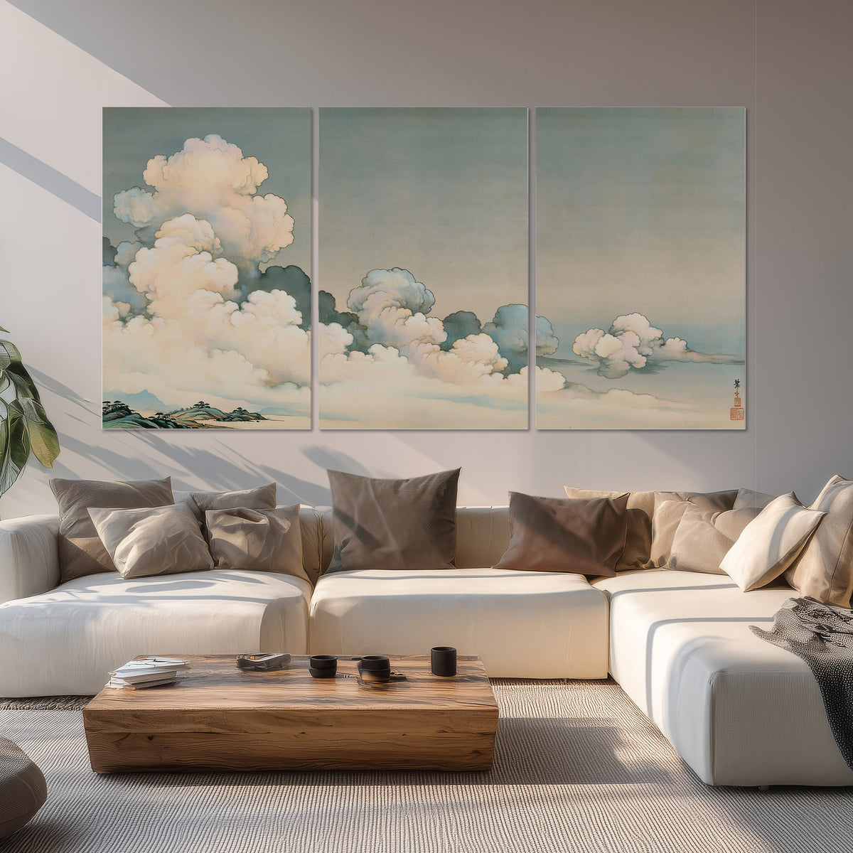 Soft cream clouds gathered low in a muted blue-green sky set of 3 poster prints displayed in a living room