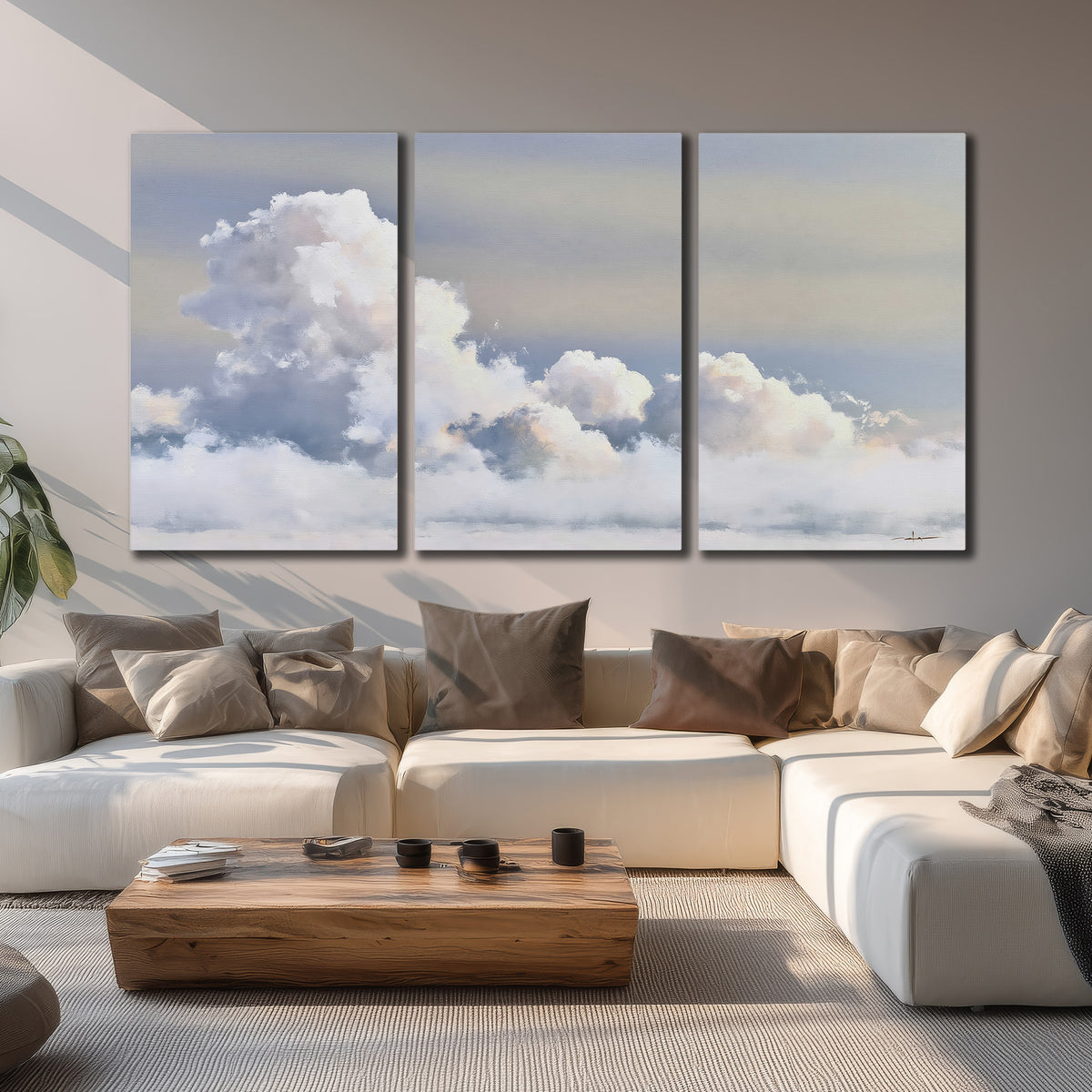 Large white clouds rising through a pale blue sky with gentle warm highlights 3 piece canvas wall art displayed in a living room