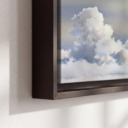 Large white clouds rising through a pale blue sky with gentle warm highlights 3 piece framed canvas wall art material and edge close up