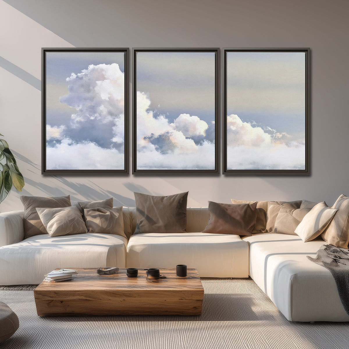 Large white clouds rising through a pale blue sky with gentle warm highlights 3 piece framed canvas wall art displayed in a living room