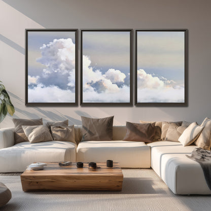 Large white clouds rising through a pale blue sky with gentle warm highlights 3 piece framed canvas wall art displayed in a living room