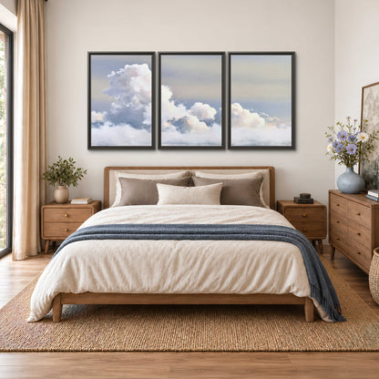 Large white clouds rising through a pale blue sky with gentle warm highlights 3 piece framed canvas wall art styled in an interior
