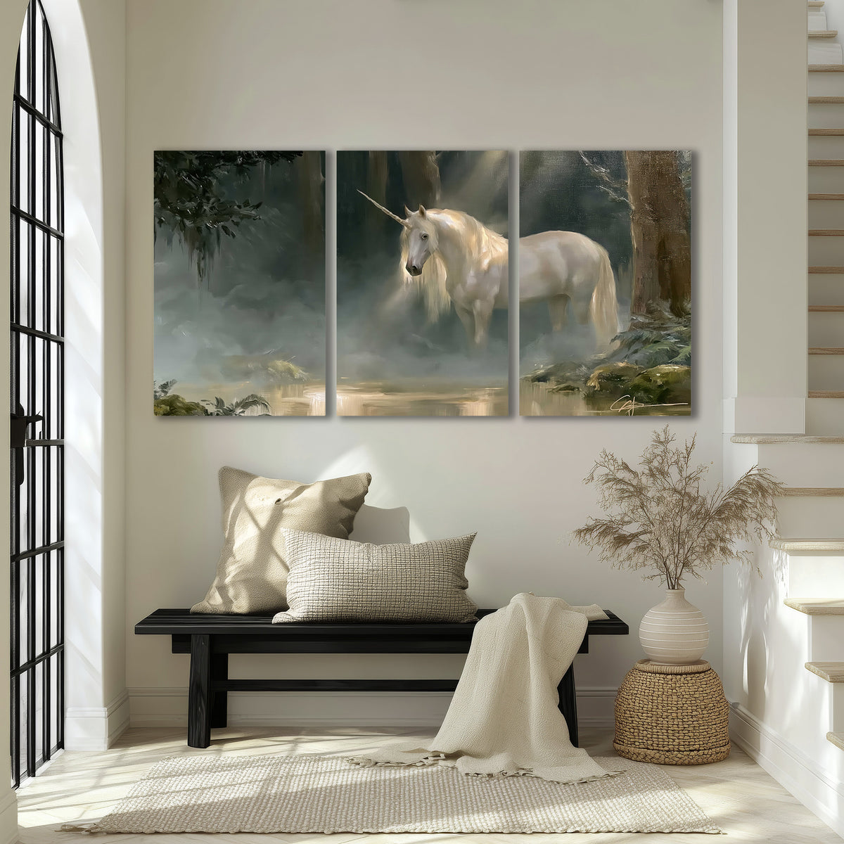 A white unicorn standing near rocks and a quiet stream in a green woodland 3 piece canvas wall art displayed in a entryway