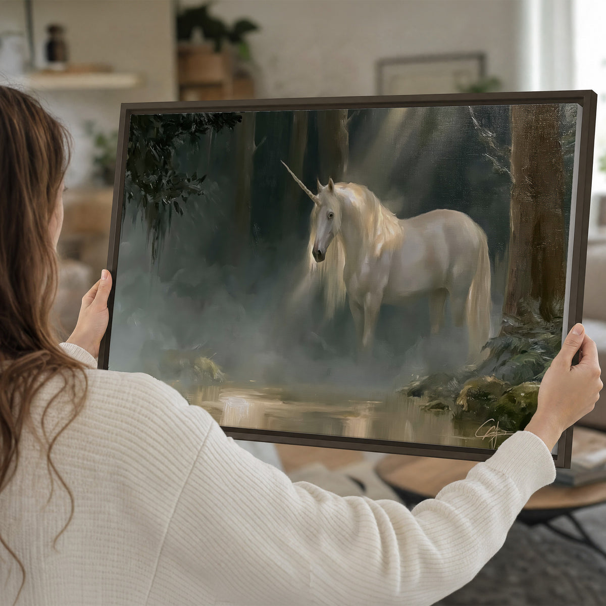 A white unicorn standing near rocks and a quiet stream in a green woodland single framed canvas wall art held in hands