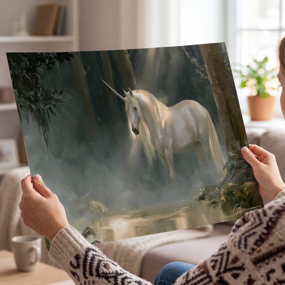 A white unicorn standing near rocks and a quiet stream in a green woodland single poster print held in hands