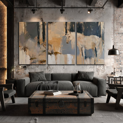 A pale unicorn emerging from loose vertical strokes of blue, ochre and cream 3 piece canvas wall art displayed in a industrial room