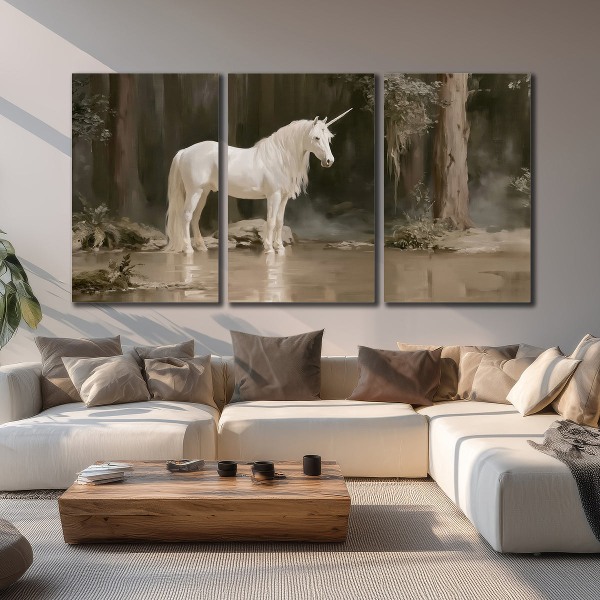 A white unicorn standing beside shallow water beneath tall shadowed trees 3 piece canvas wall art displayed in a living room