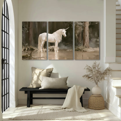 A white unicorn standing beside shallow water beneath tall shadowed trees 3 piece canvas wall art displayed in a entryway