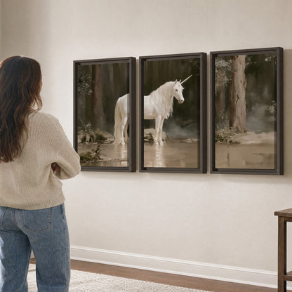 A white unicorn standing beside shallow water beneath tall shadowed trees 3 piece framed canvas wall art three panel arrangement on a wall