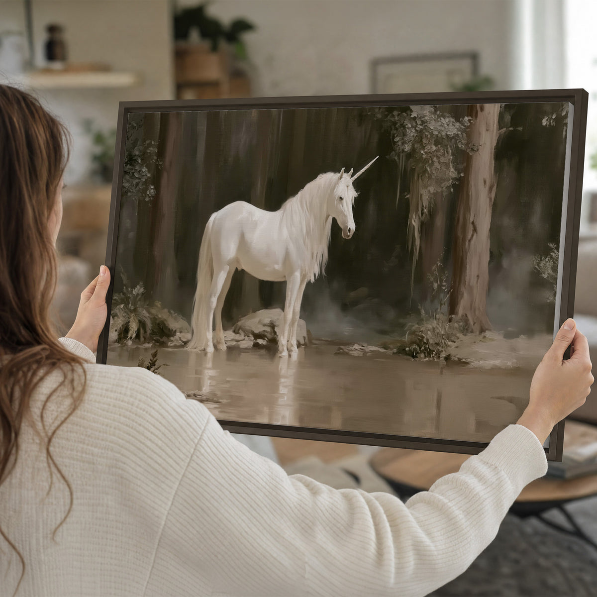 A white unicorn standing beside shallow water beneath tall shadowed trees single framed canvas wall art held in hands