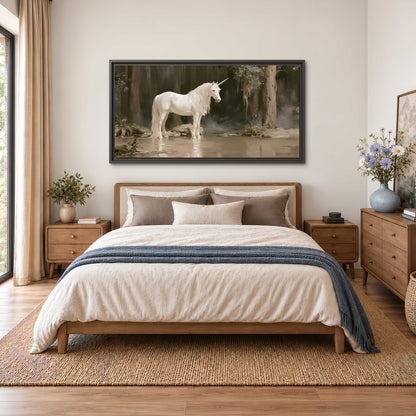 A white unicorn standing beside shallow water beneath tall shadowed trees single framed canvas wall art styled in an interior