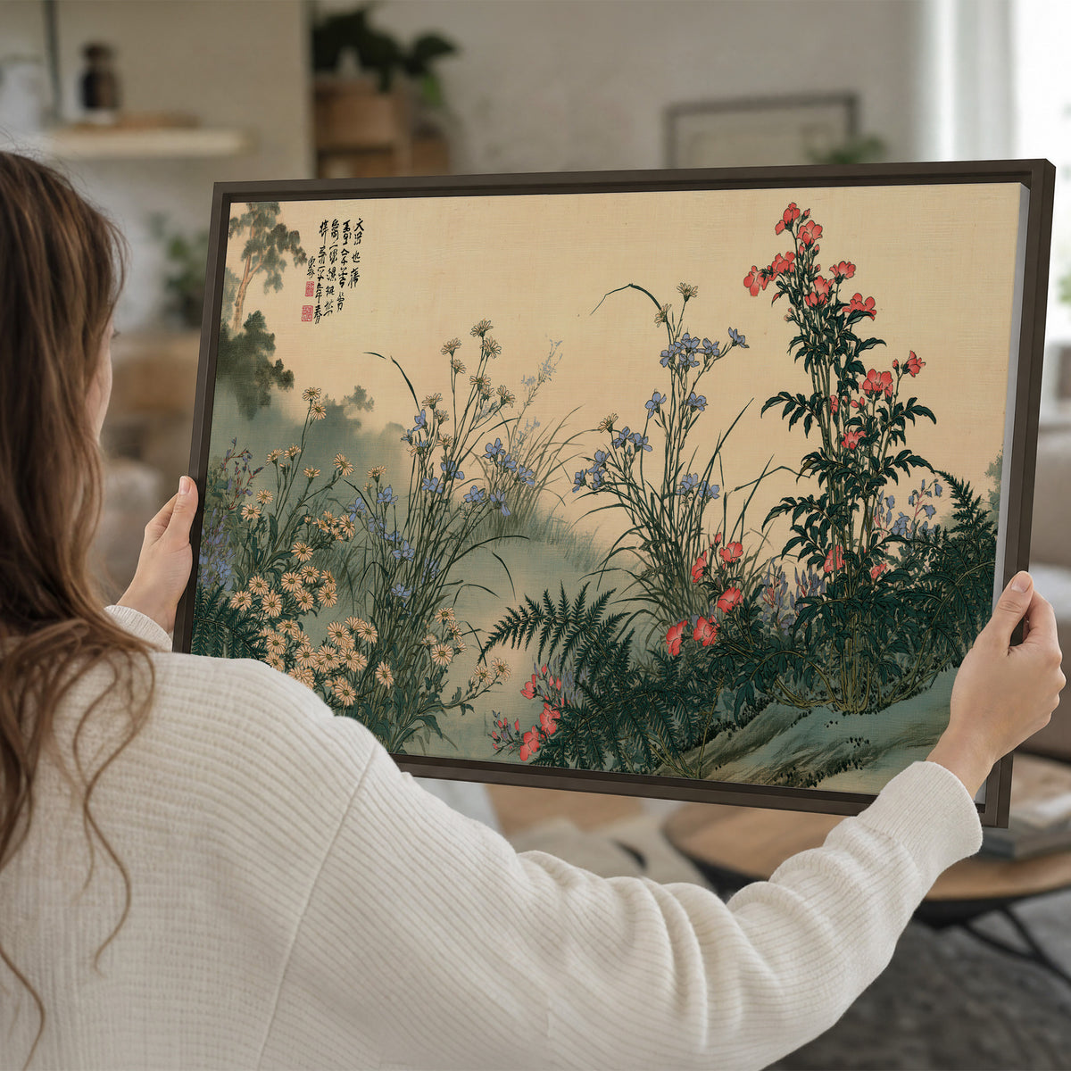 Delicate wildflowers and ferns arranged on a warm neutral ground with decorative script single framed canvas wall art held in hands