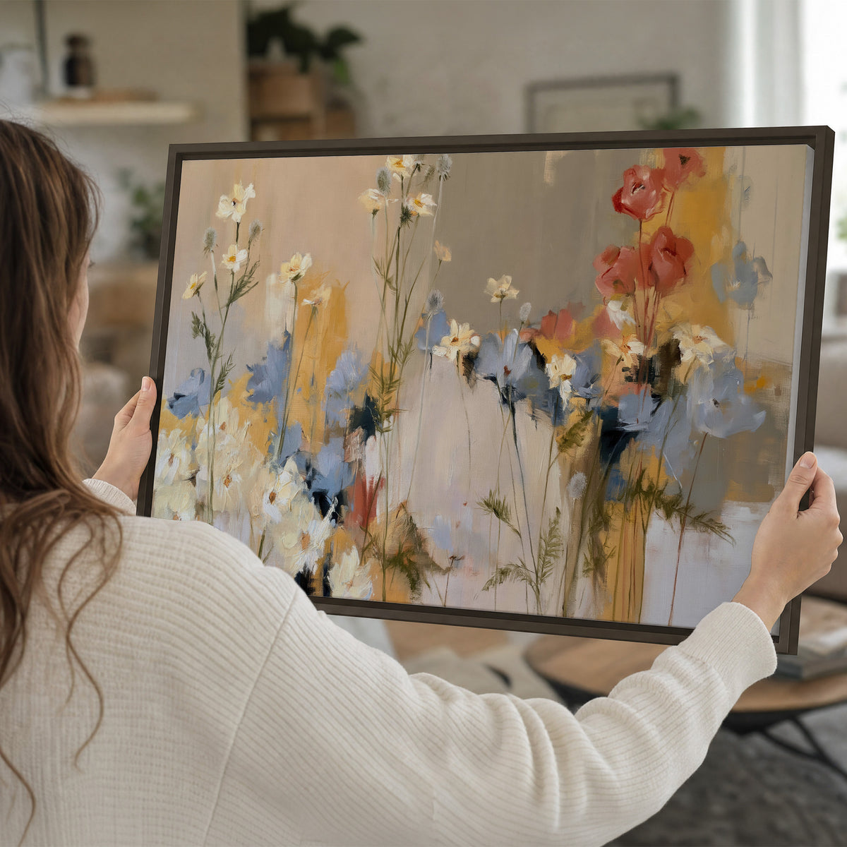 Loose white and yellow flowers set against vertical blue and golden strokes single framed canvas wall art held in hands