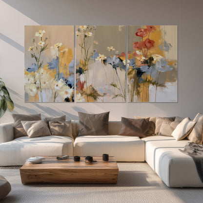 Loose white and yellow flowers set against vertical blue and golden strokes set of 3 poster prints displayed in a living room