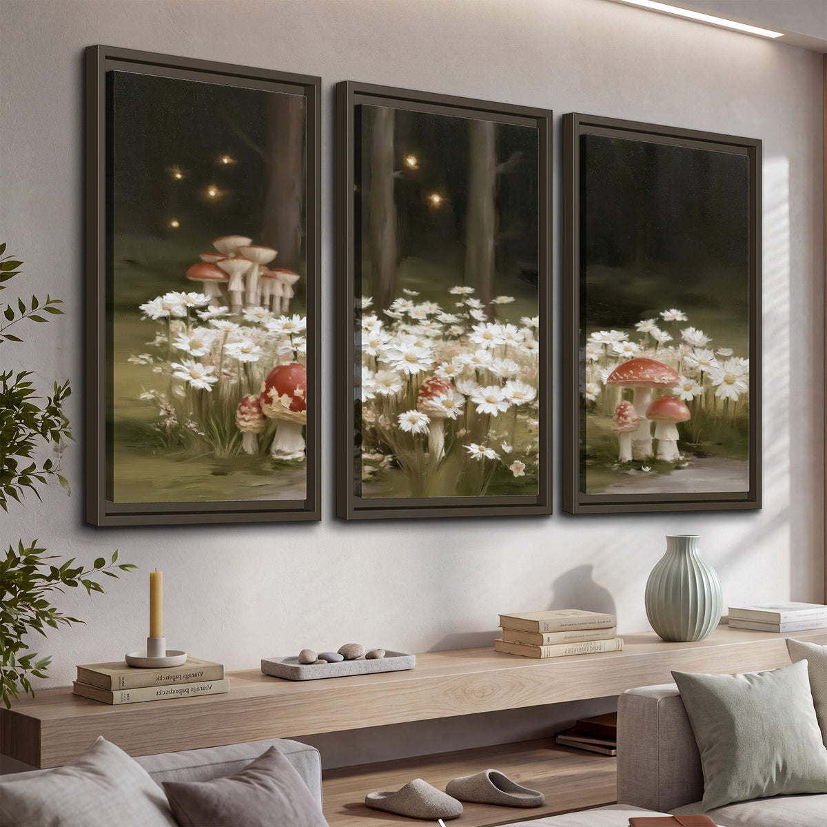 Pale daisies and red-capped mushrooms in a dark meadow with tiny painted points of light 3 piece framed canvas wall art displayed in a console