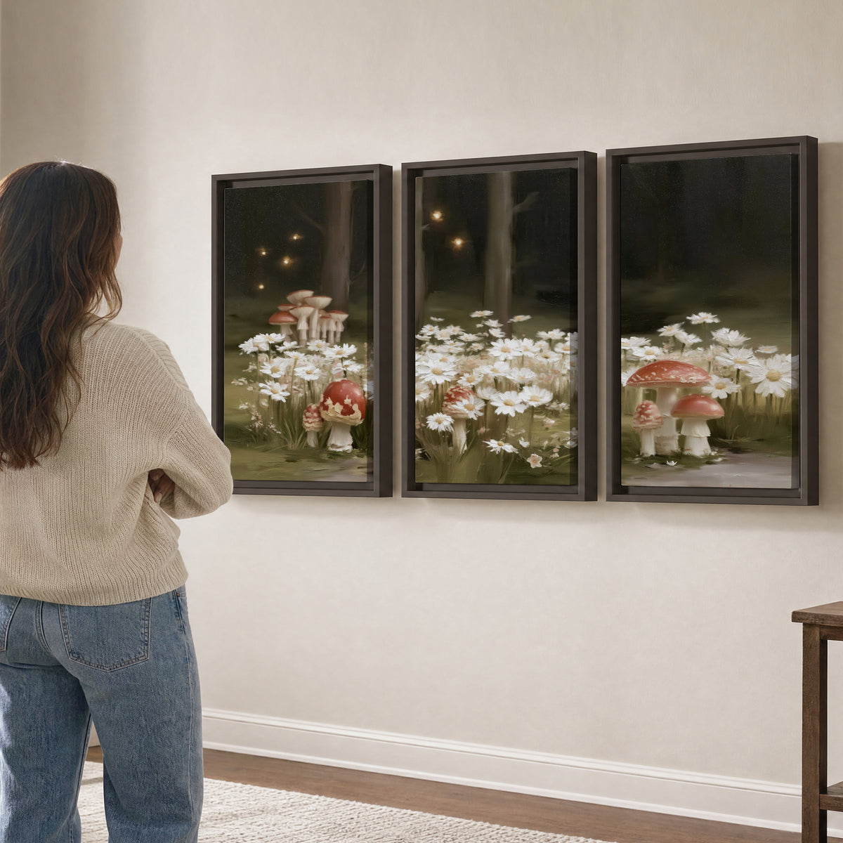 Pale daisies and red-capped mushrooms in a dark meadow with tiny painted points of light 3 piece framed canvas wall art three panel arrangement on a wall