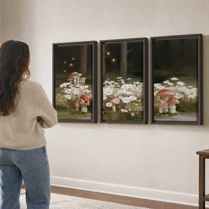 Pale daisies and red-capped mushrooms in a dark meadow with tiny painted points of light 3 piece framed canvas wall art three panel arrangement on a wall