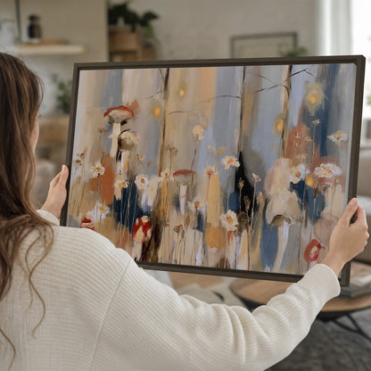 Loose mushroom and flower forms among vertical blue, ochre and cream strokes single framed canvas wall art held in hands