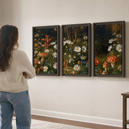 White daisies and warm red mushrooms scattered across a dark woodland garden 3 piece framed canvas wall art three panel arrangement on a wall