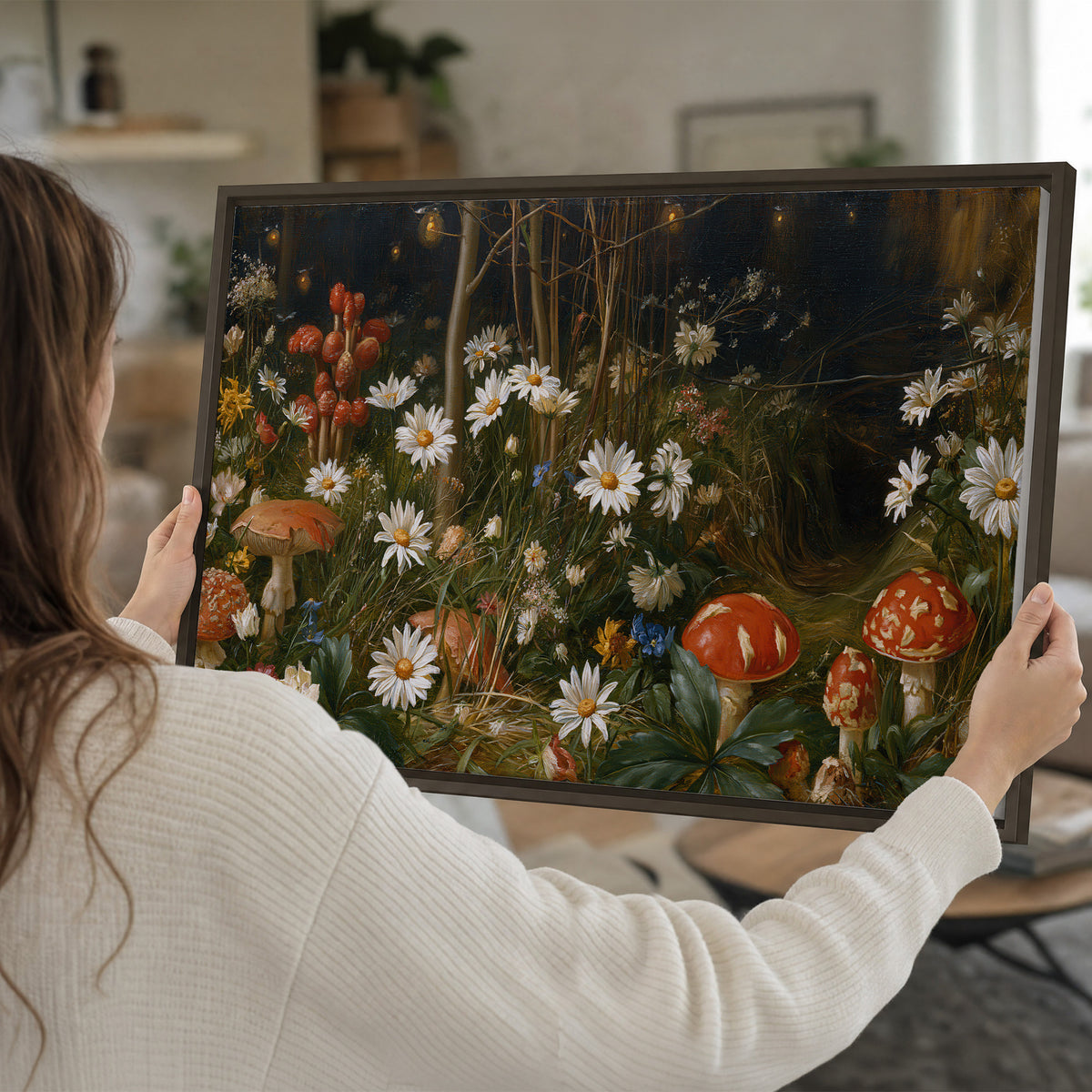 White daisies and warm red mushrooms scattered across a dark woodland garden single framed canvas wall art held in hands