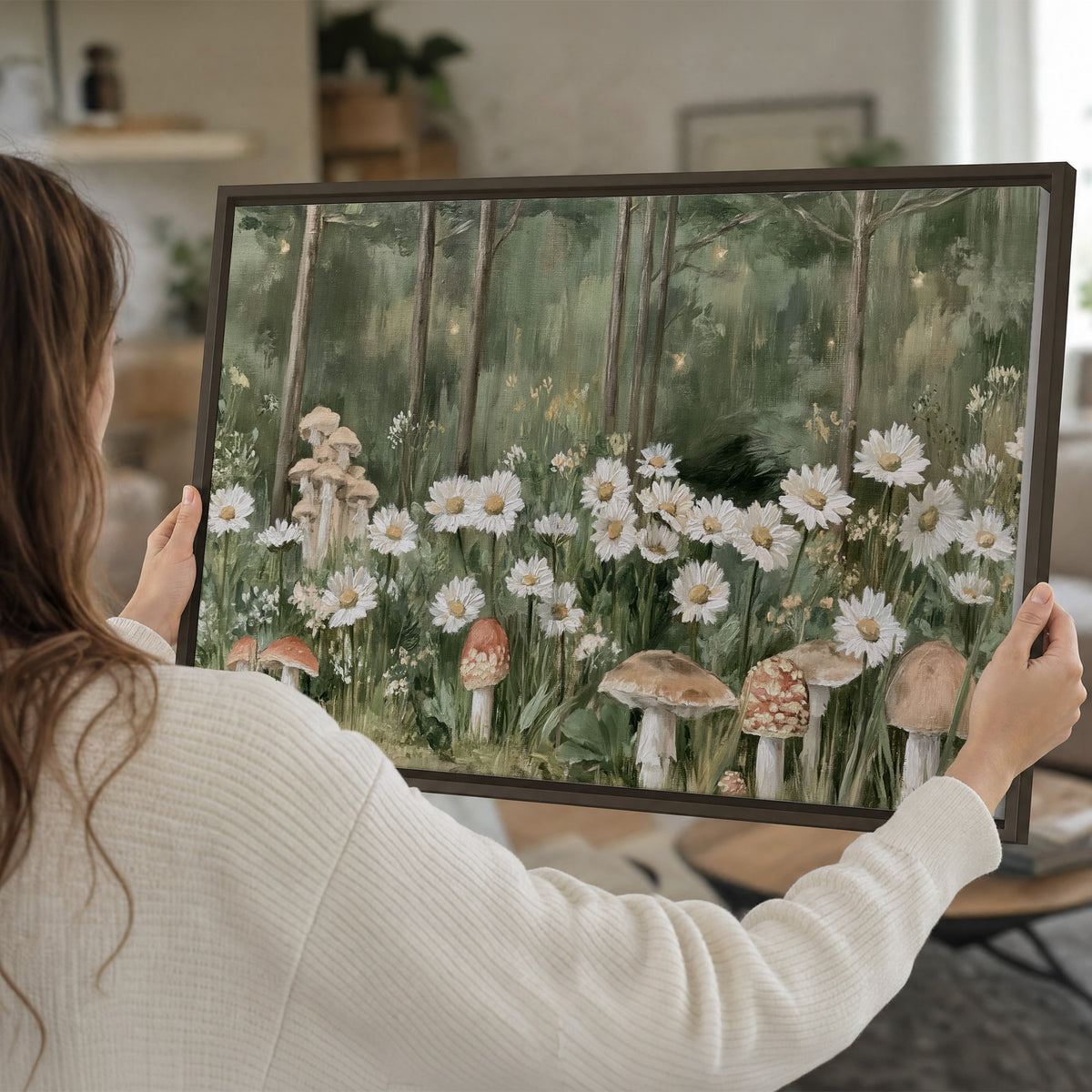 Pale pink mushrooms nestled among white daisies and tall green woodland grasses single framed canvas wall art held in hands