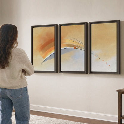 A sweeping ochre and orange arc with fine blue accents on a warm cream background 3 piece framed canvas wall art three panel arrangement on a wall